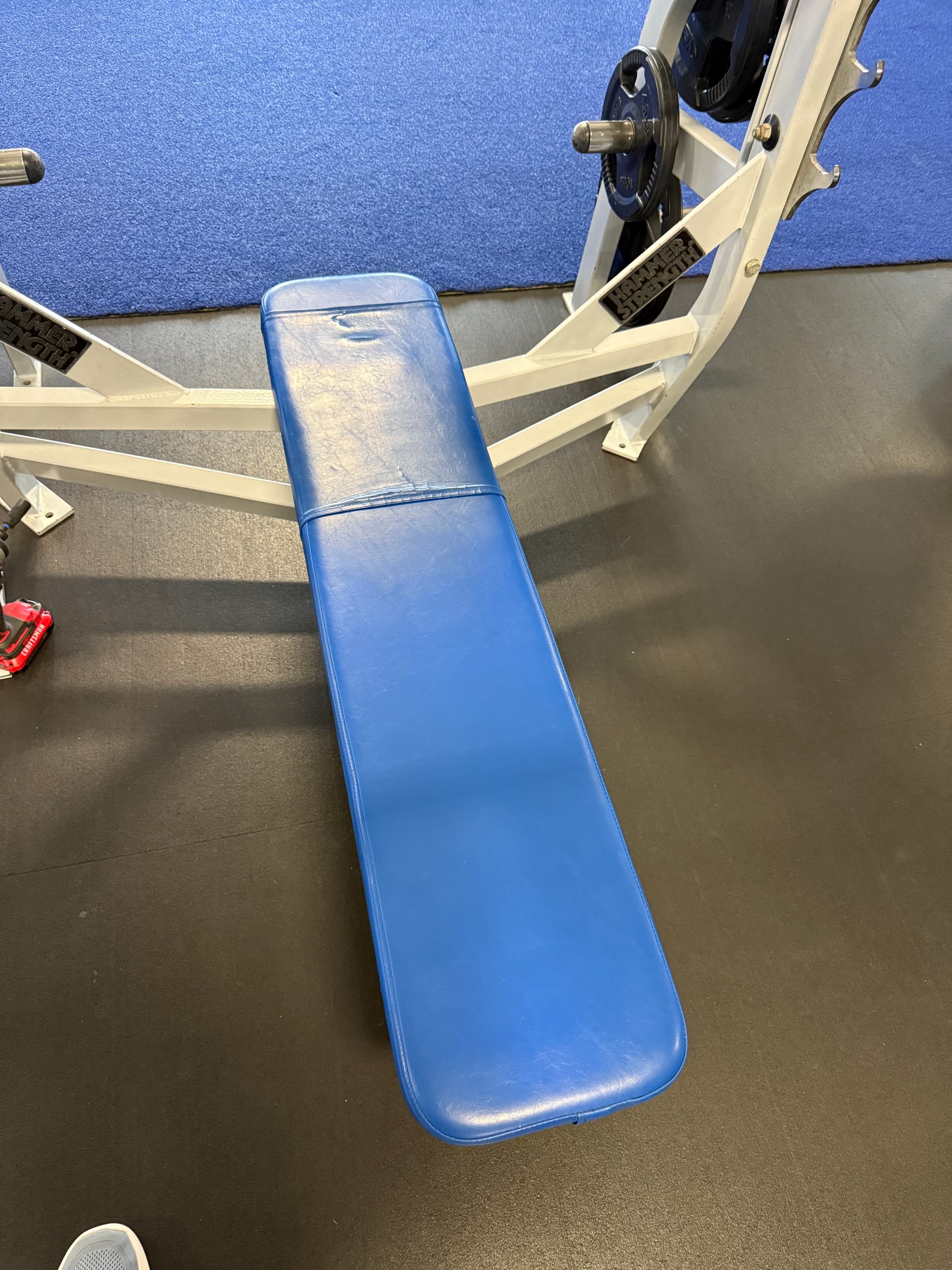 Commercial gym bench with worn blue upholstery before restoration