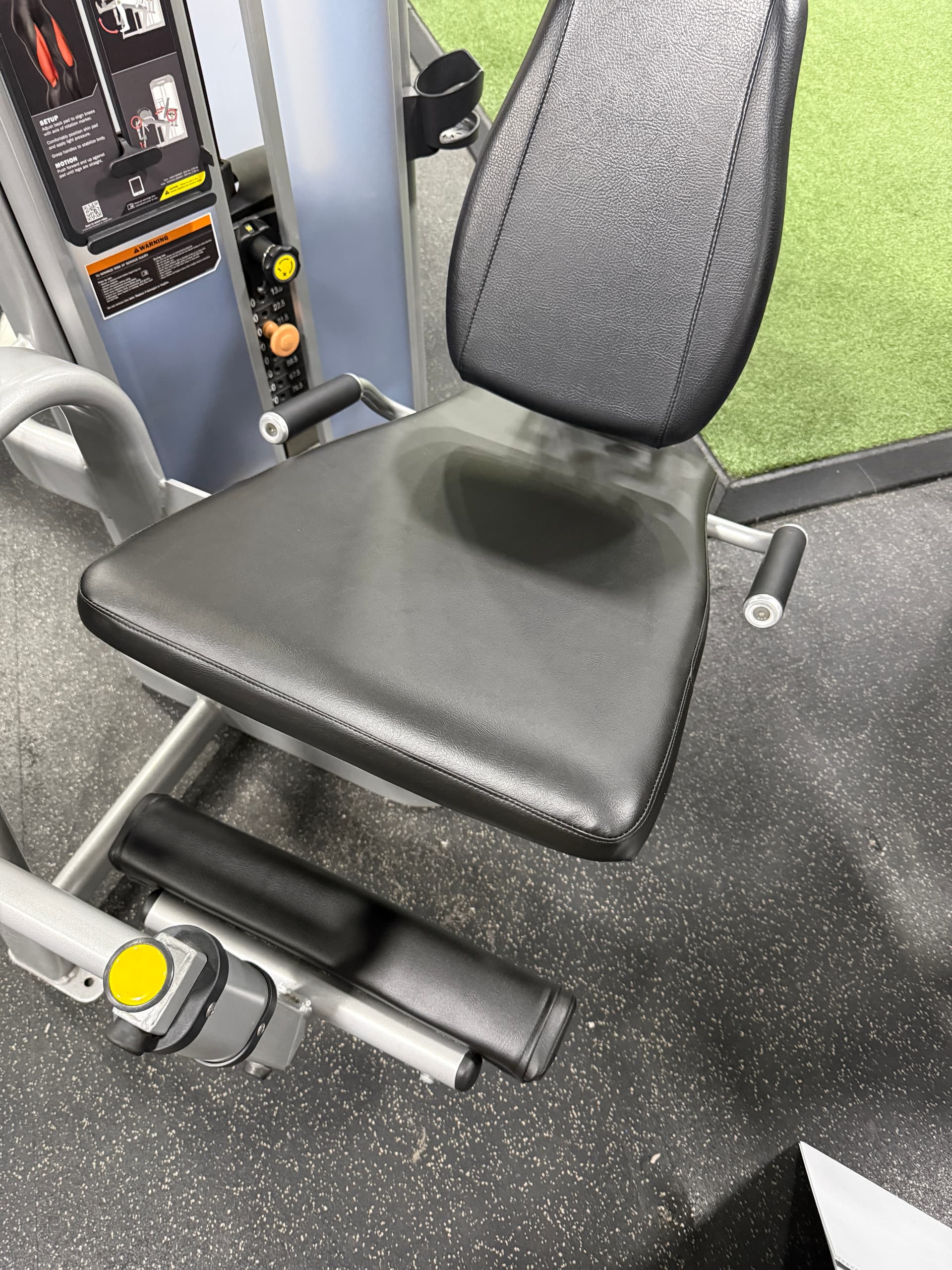 Commercial gym station on green turf with restored black upholstery