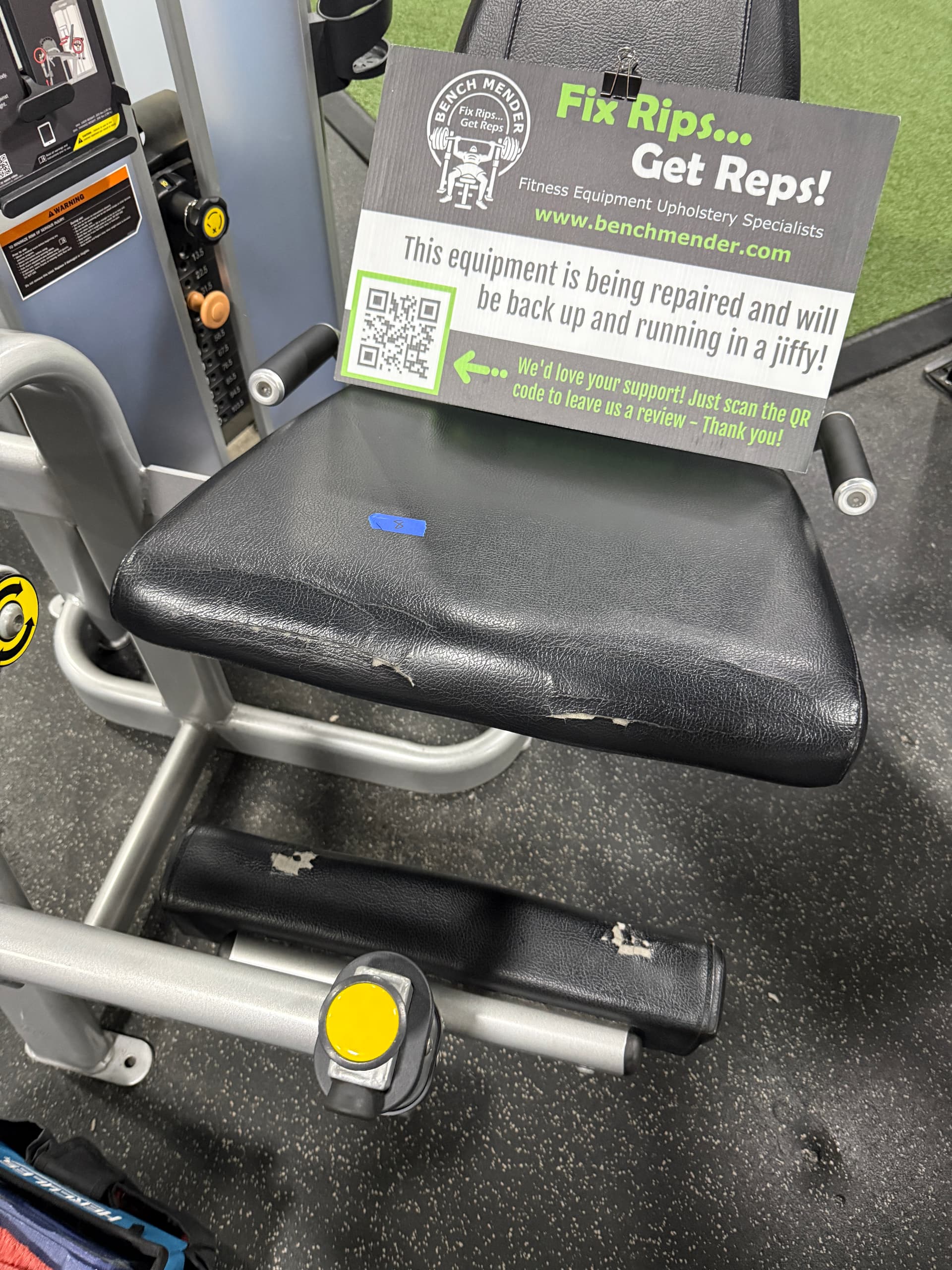 Commercial gym station on green turf before upholstery restoration