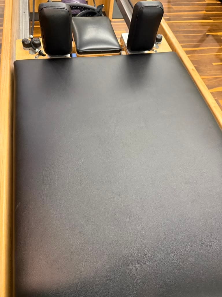 Pilates reformer pad with smooth black replacement upholstery